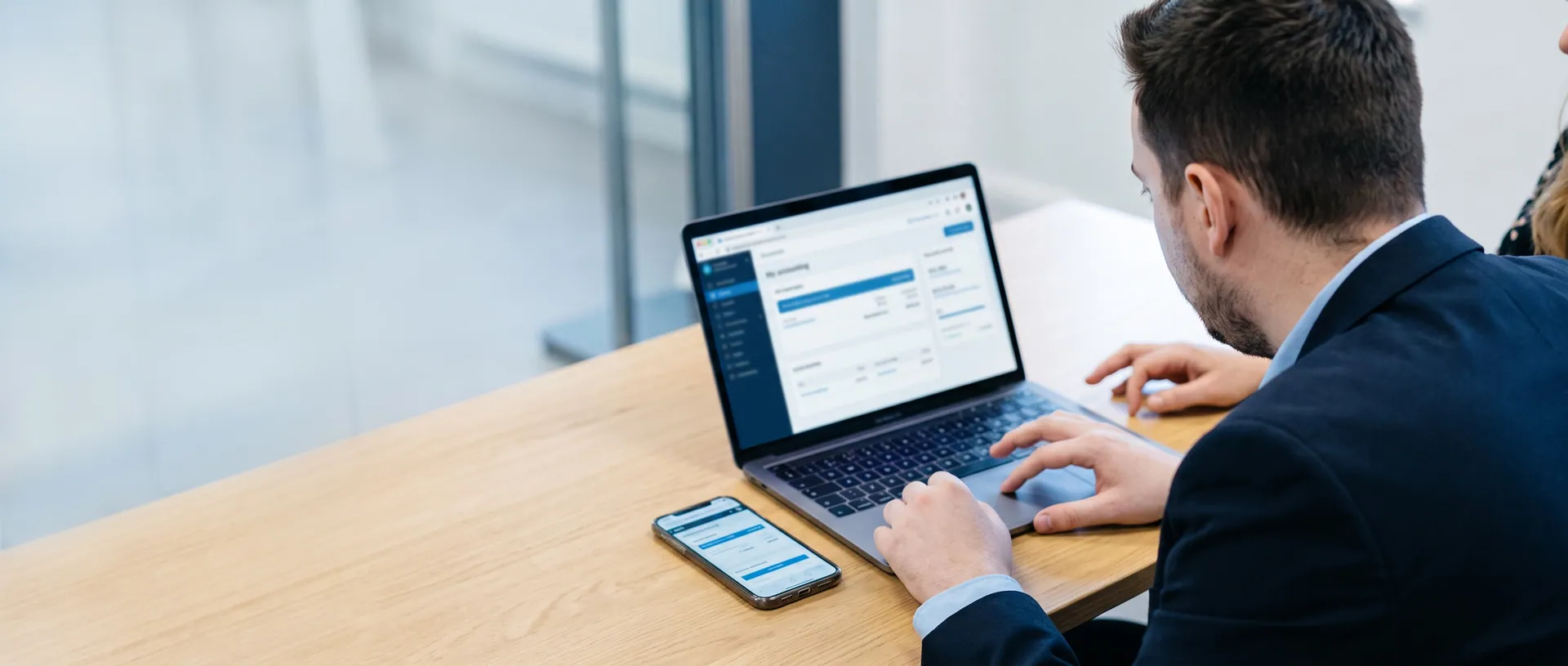 Berater zeigt einer Kundin die bexio-Software am Laptop